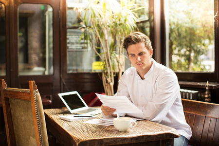 外国人厨师年轻的厨师坐在办公室看文件照片