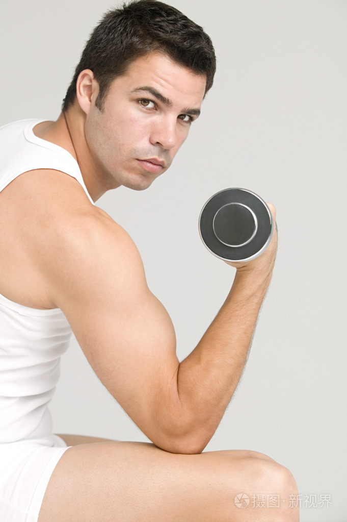 拿着哑铃锻炼的男人