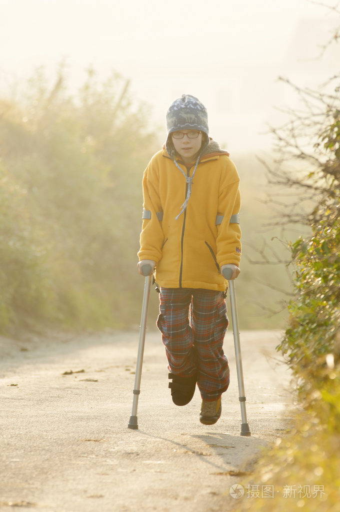 在雾气弥漫的乡间小路上拐杖的女孩