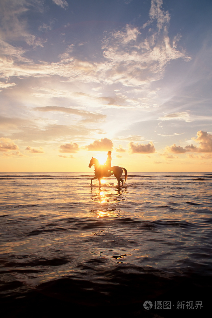 日落时在海上骑马的人