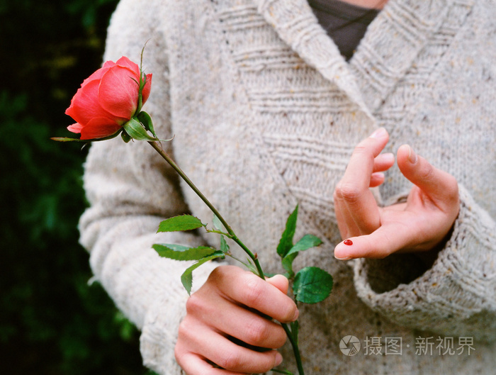 被玫瑰刺伤了手指的女孩