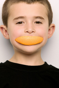 残幅人像焦段在吃橘子片的男孩照片