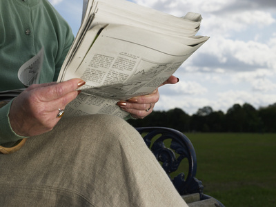 天空报纸看报纸的老年妇女照片