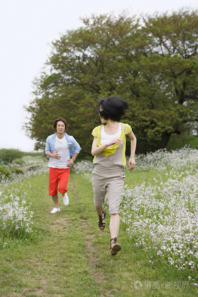 年轻夫妇在田野里奔跑