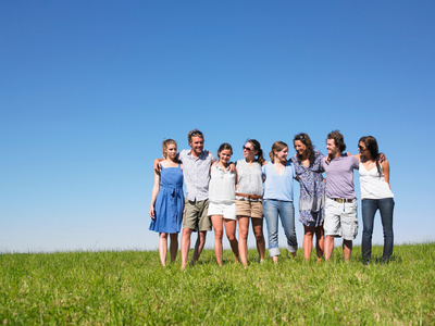 草地蓝天大自然一群年轻人在野外行走照片