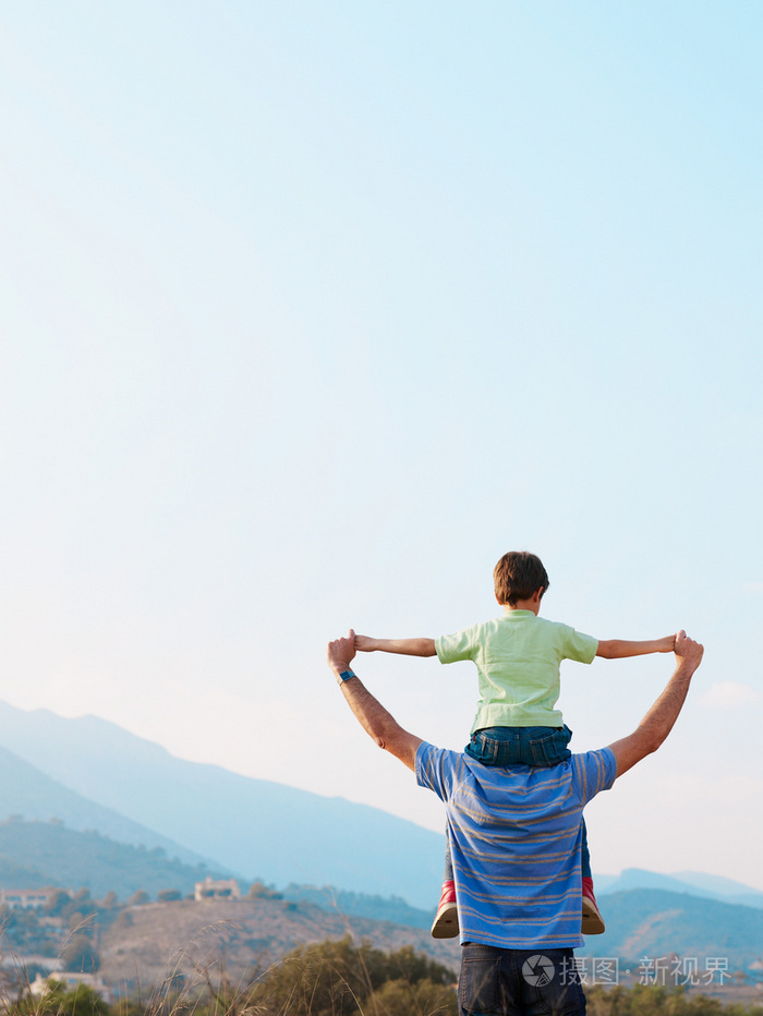 儿子骑在父亲的肩上