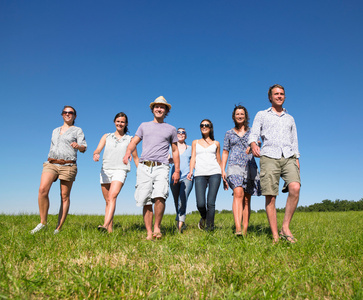 草地蓝天大自然一群年轻人在野外行走照片
