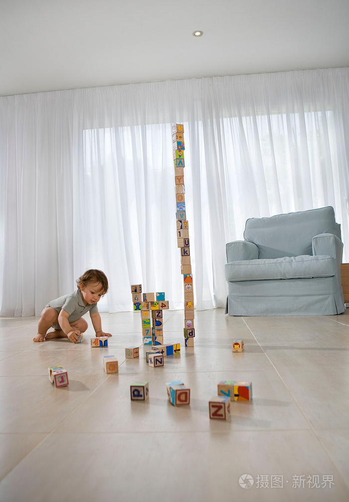 婴儿坐在地板上玩方块游戏