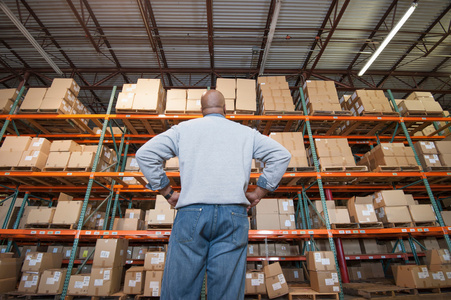 货架上牛仔裤仓库工人看着货架上的纸板箱照片