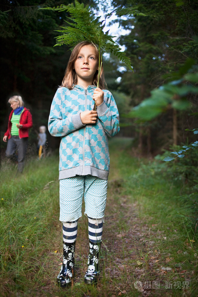 穿雨靴的女孩走在森林里