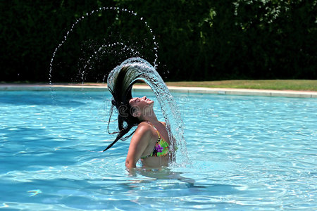 游泳池里的女孩或女人把湿头发向后扔