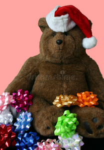 圣诞泰迪熊戴着粉色背景的圣诞老人帽