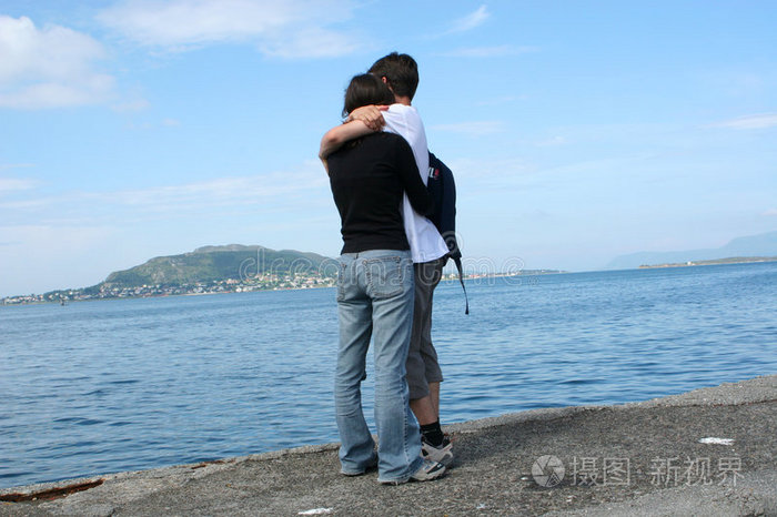 站在岸边望着大海的年轻男女