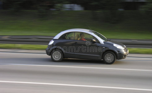 在高速公路上超速行驶的小汽车照片