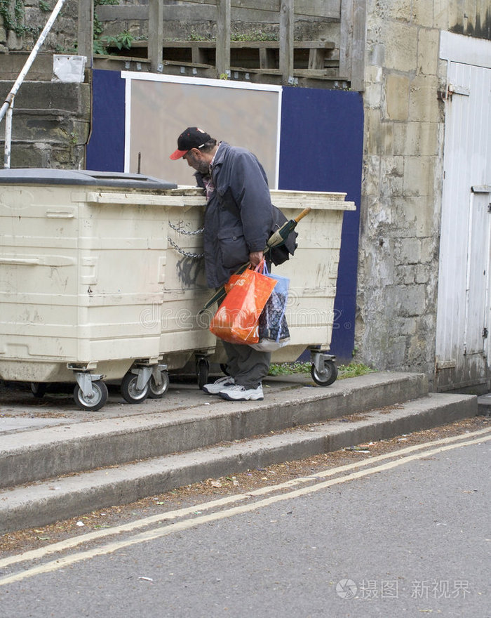 男孩又害怕又脏的棕色头发的孩子在公园长椅上无家可归流浪汉和纸板无