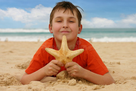 海滩上抱着海星的男孩