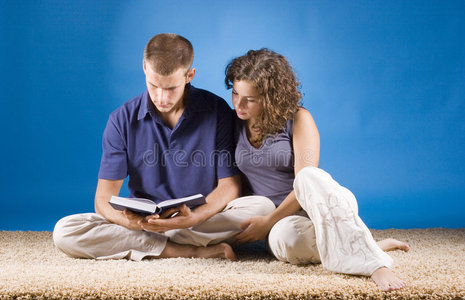 坐在米黄色地毯上的年轻夫妇