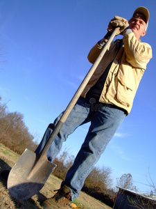 农民拿着铲子站着照片