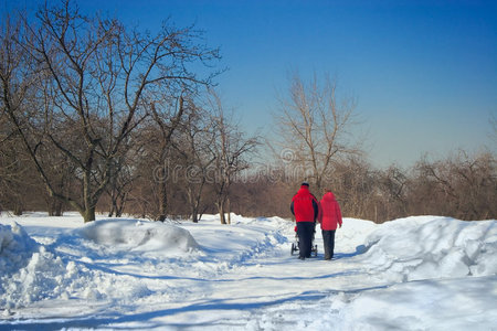 带着孩子在冬季公园散步的年轻父母