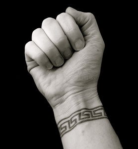 女小腿纹身图案大全黑色背景上有希腊钥匙图案手腕纹身的拳头照片