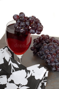 一杯红酒配葡萄和一张黑白餐巾