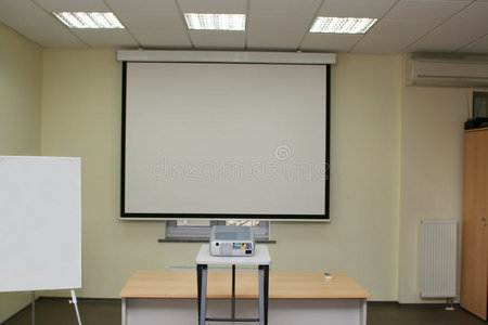 会议室投影屏幕，桌上有投影仪