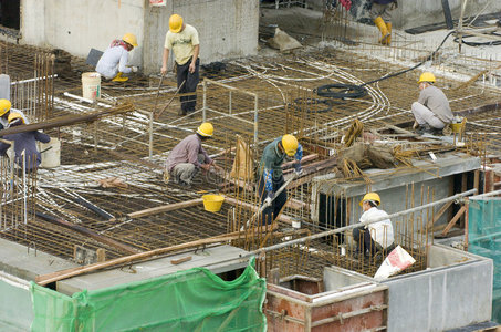 软管钢筋拼装建设的一家公寓批制作钢钢筋的建筑工人工作中的钢筋弯