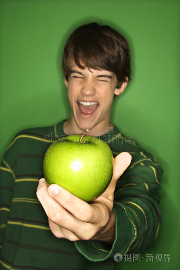 一位妇女拿着健康食品的特写照片吃苹果的男孩头上戴着苹果的白人男孩