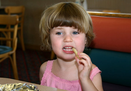 吃炸薯条的小女孩