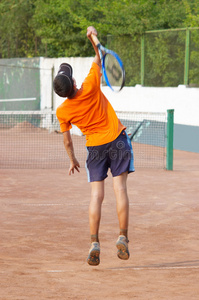 网球。男孩在服侍