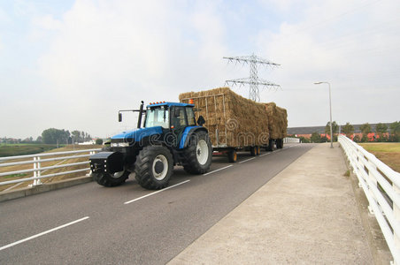 拖拉车带干草车的拖拉机照片