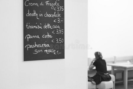 墙上咖啡馆的菜单，女人坐在