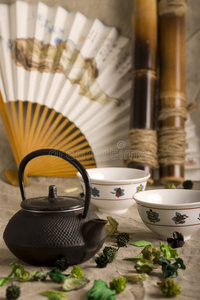中国茶壶，两杯，扇子和竹子