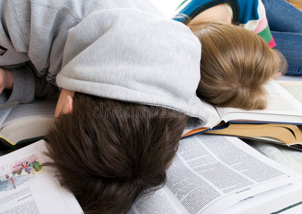 疲倦的学生睡在书上