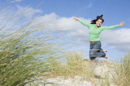 年轻女子在沙丘间跳跃