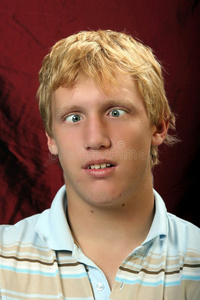 斜眼男人盯着他的笔记本电脑屏幕人的面部表情老人人控股的书,眼镜有