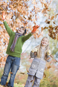 两个孩子向空中扔树叶