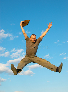 在金币钱上跳了起来成功的商人,在金币钱上跳了起来一群年轻快乐笑的