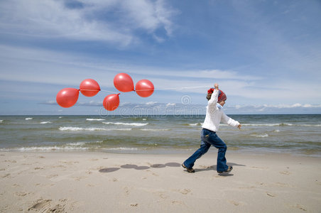 海滩上有红色气球的可爱女孩