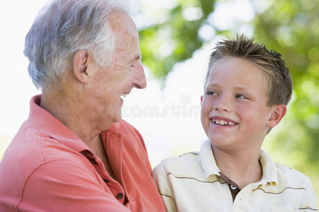 爷爷和孙子在户外微笑。