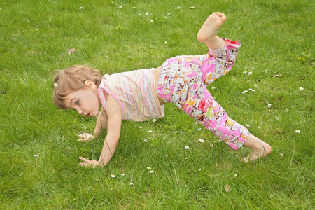小女孩在草地上做体操