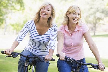 两个骑自行车在户外微笑的朋友