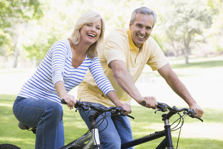 在户外骑自行车的夫妇微笑着
