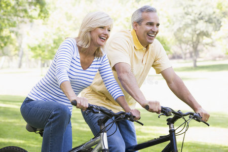 在户外骑自行车的夫妇微笑着