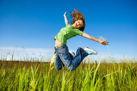 快乐的年轻女子在田里跳跃