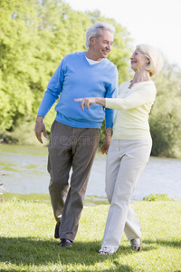 在湖边公园散步的夫妇微笑着