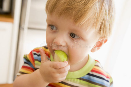 小男孩在室内吃苹果