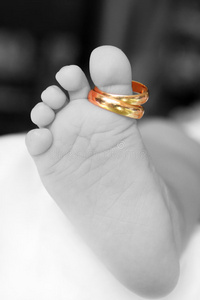 婴儿的脚特写有两个金色的戒指图片