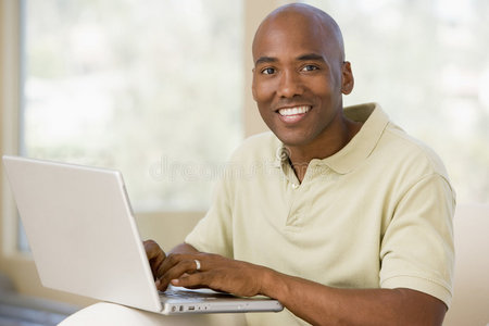 客厅里的男人用笔记本电脑微笑着
