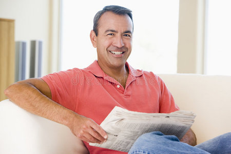 在客厅看报纸的男人微笑着